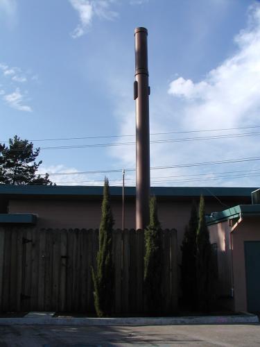 This is a full view of the brown painted tower behind an 8 ft. wooden fence.